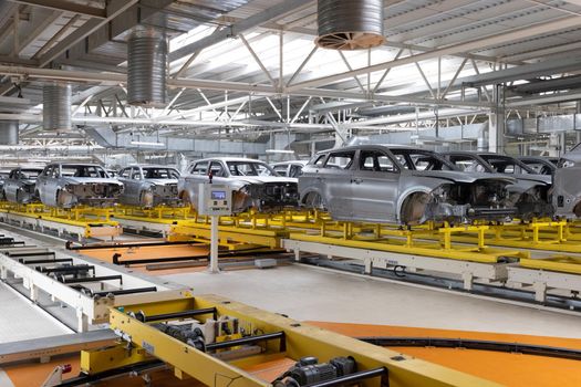 Car bodies are on assembly line. Factory for production of cars. Modern automotive industry.