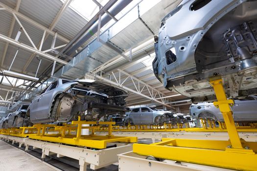 Car bodies are on assembly line. Factory for production of cars. Modern automotive industry.