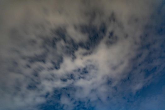 Dark blue sky on long exposure with moving clouds at night 