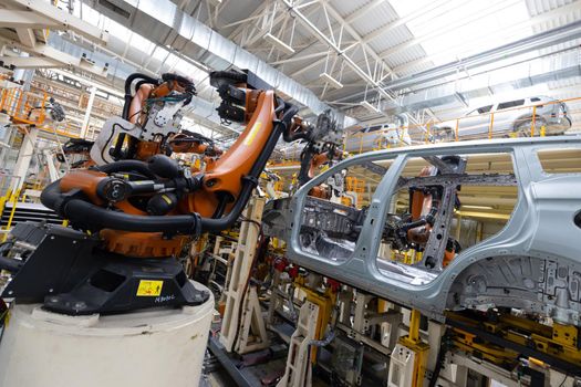 Photo of automobile production line. Welding car body. Modern car assembly plant. Auto industry. Interior of a high-tech factory, modern production.