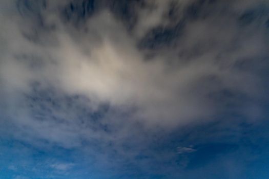 Dark blue sky on long exposure with moving clouds at night 