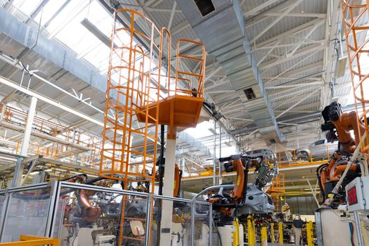 Photo of automobile production line. Welding car body. Modern car assembly plant. Auto industry. Interior of a high-tech factory, modern production.