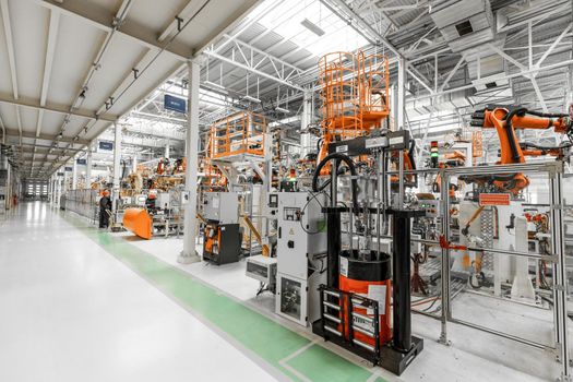 Photo of automobile production line. Welding car body. Modern car assembly plant. Auto industry. Interior of a high-tech factory, modern production.