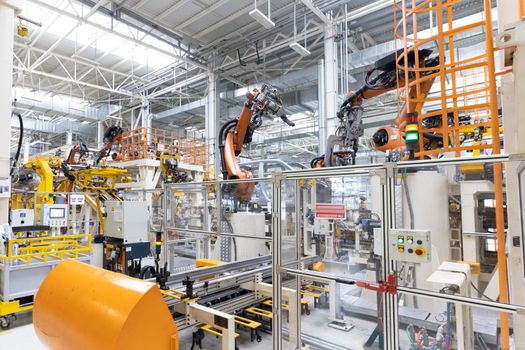 Photo of automobile production line. Welding car body. Modern car assembly plant. Auto industry. Interior of a high-tech factory, modern production.