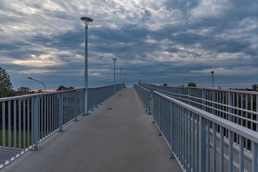 Long high concrete footbridge over city highway