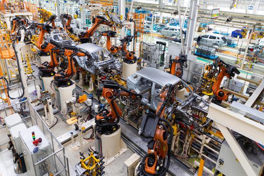 Car bodies are on assembly line. Factory for production of cars. Modern automotive industry. Electric car factory, conveyor.