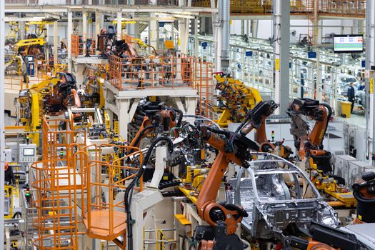 Car bodies are on assembly line. Factory for production of cars. Modern automotive industry. Electric car factory, conveyor.