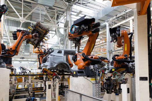 Photo of automobile production line. Modern car assembly plant. Auto industry. Interior of a high-tech factory, modern production.