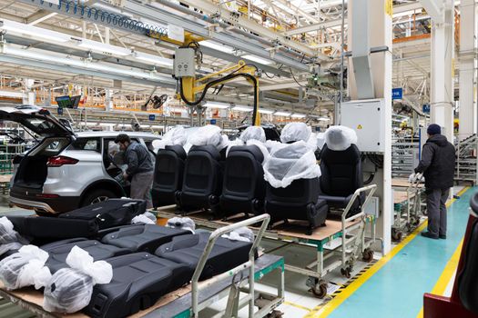 Photo of automobile production line. Modern auto assembly plant. Car black seats.