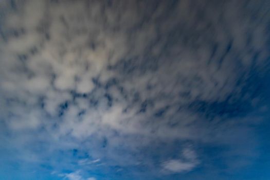 Dark blue sky on long exposure with moving clouds at night 