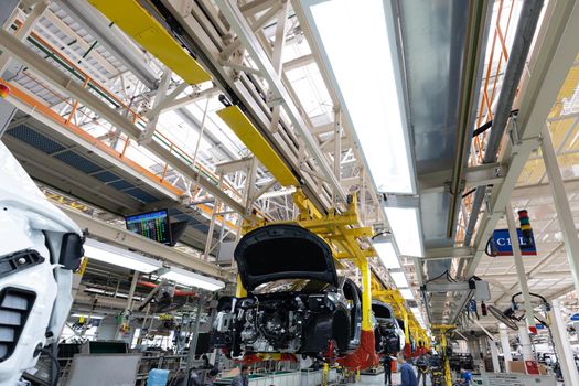 Minsk, Belarus - Dec 15, 2021: Car bodies are on assembly line. Factory for production of cars. Modern automotive industry. A car being checked before being painted in a high-tech enterprise.