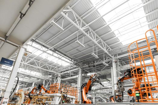 Photo of automobile production line. Welding car body. Modern car assembly plant. Auto industry. Interior of a high-tech factory, modern production.