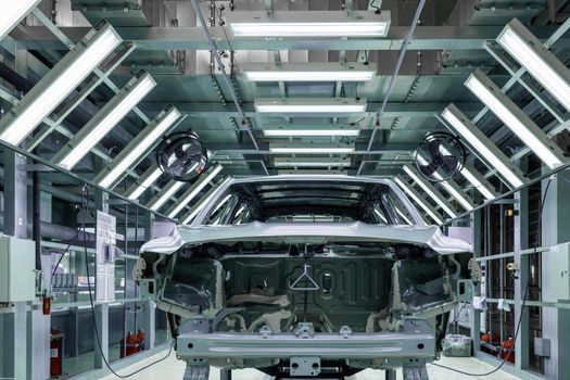 Car bodies are on assembly line. Factory for production of cars. Modern automotive industry.