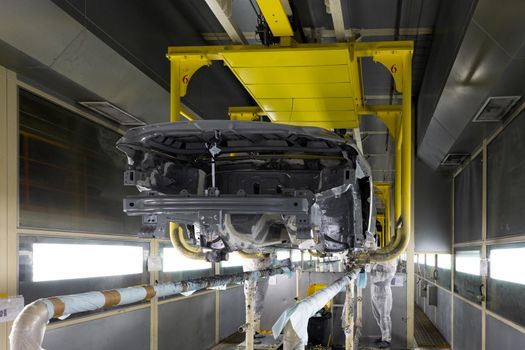 Car bodies are on assembly line. Modern automotive industry. A car being checked before being painted in a high-tech enterprise.