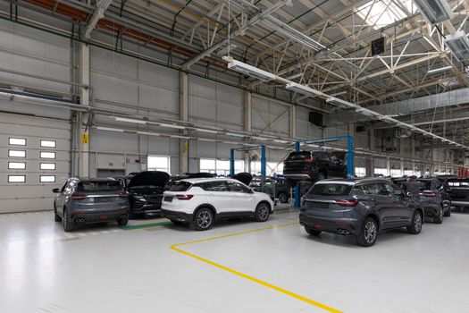 Photo of modern car assembly plant. Interior of a high-tech factory of new automobiles.