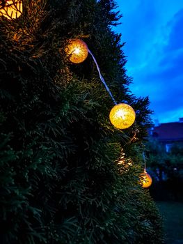 Small glowing light balls hanging on a tree