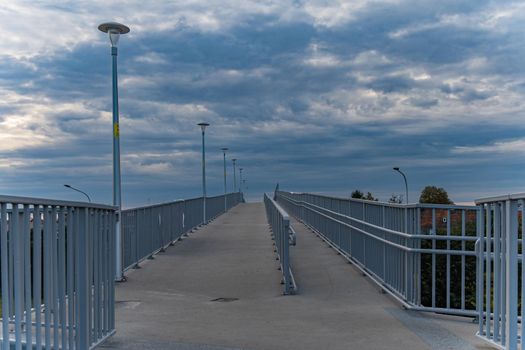 Long high concrete footbridge over city highway