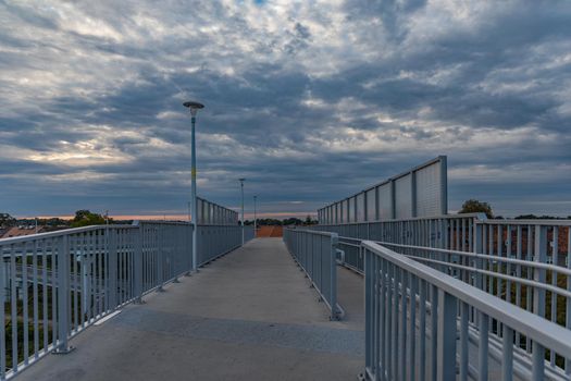 Long high concrete footbridge over city highway