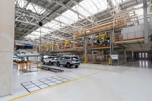 Photo of modern car assembly plant. Interior of a high-tech factory of new automobiles.