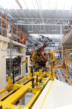 Vertical photo of automobile production line. Welding car body. Modern car assembly plant. Auto industry.