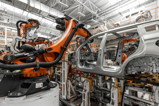 Photo of automobile production line. Welding car body. Modern car assembly plant. Auto industry. Interior of a high-tech factory, modern production.