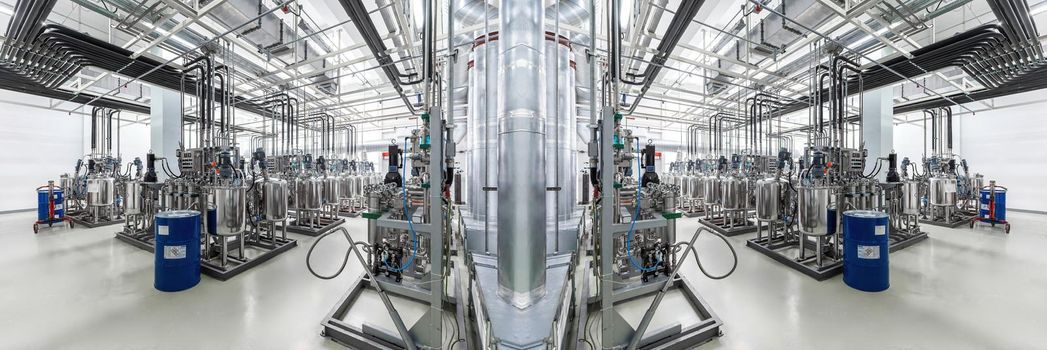 Panoramic mirror photo of pipes and tanks. Chemistry and medicine production. Pharmaceutical factory. Interior of a high-tech factory, modern production.