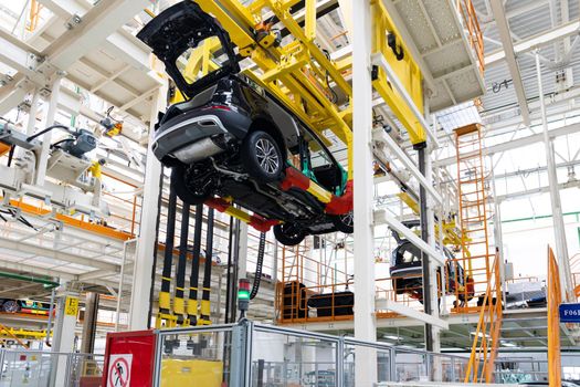 Photo of automobile production line. Welding car body. Modern car assembly plant. Auto industry. Interior of a high-tech factory.