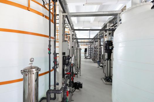 Close-up photo of white pipes and tanks. Chemistry and medicine production. Pharmaceutical factory. Interior of a high-tech factory.