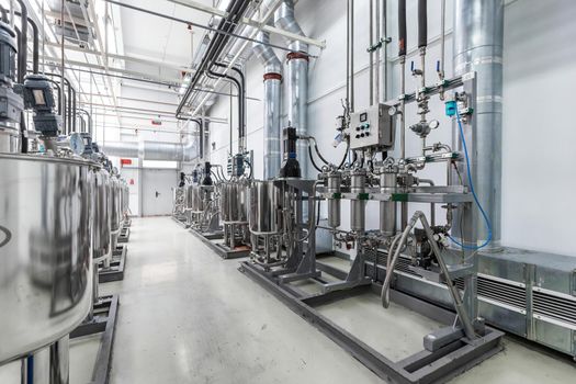 Photo of pipes and tanks. Chemistry and medicine production. Pharmaceutical factory. Interior of a high-tech factory, modern production.