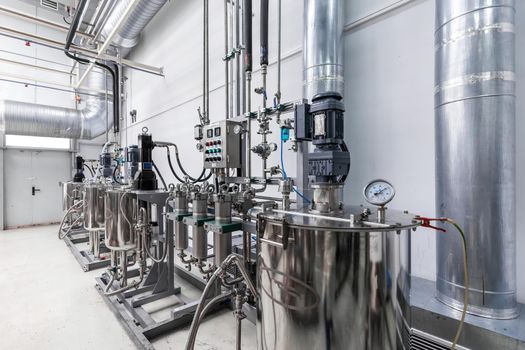 Photo of pipes and tanks. Chemistry and medicine production. Pharmaceutical plant. Interior of a high-tech factory.