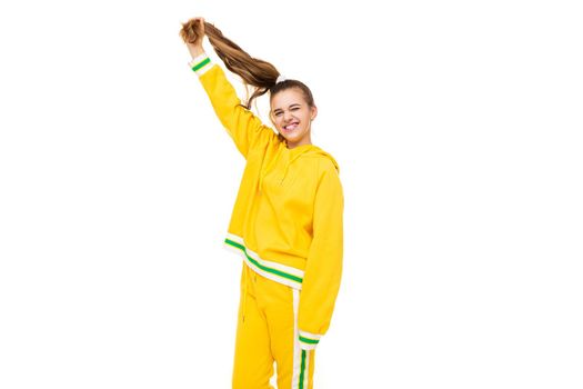 Photo of beautiful funny happy wonderful smiling cute girl with dark hair with ponytail in stylish yellow tracksuit with green stripes isolated on white background with free space for text.