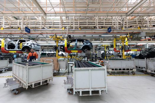Minsk, Belarus - Dec 15, 2021: Car bodies are on assembly line. Factory for production of cars. Modern automotive industry. A car being checked before being painted in a high-tech enterprise.