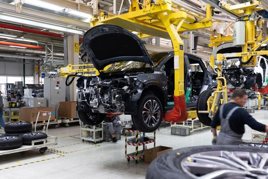 Car bodies are on assembly line. Factory for production of cars. Modern automotive industry. A car being checked before being painted in a high-tech enterprise.