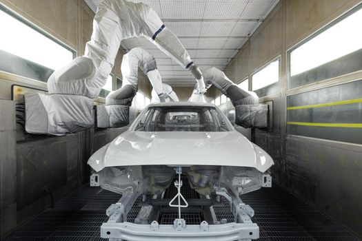 Car bodies are on assembly line. Modern automotive industry. A car being painted in a high-tech enterprise.