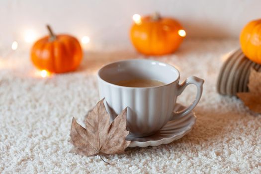 cosy autumn composition with hot drink and mini pumpkins, side view, selective focus