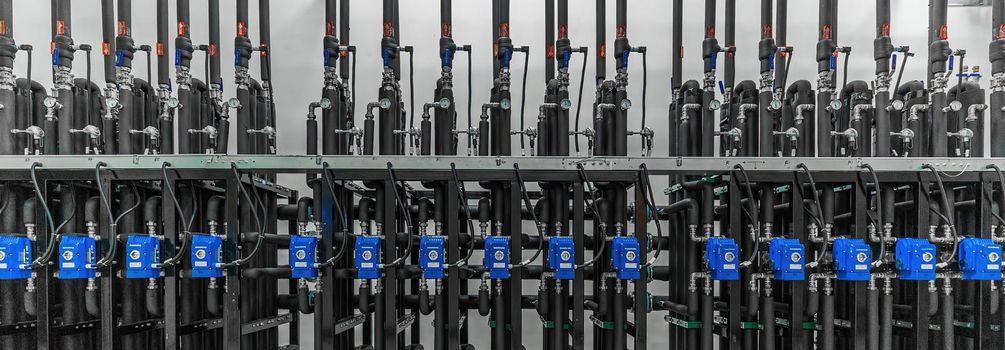 Panoramic photo of production pumps on the wall in a modern factory. Chemistry and medicine production. Pharmaceutical high-tech plant interior.