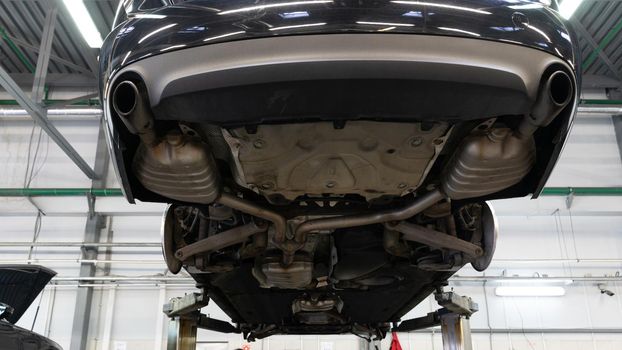 car underbody on a lift at an authorized workshop.