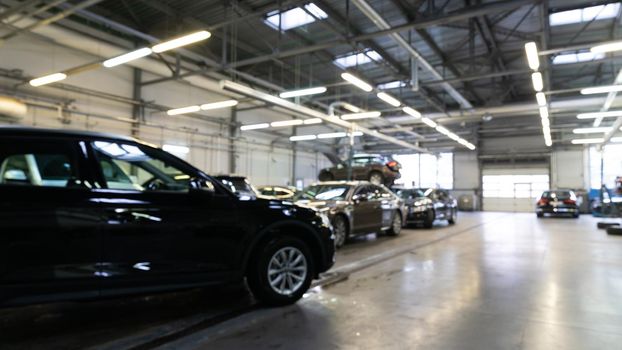 automotive locksmith workshop at an authorized dealer with cars awaiting and repairing. blurred photo with depth of field