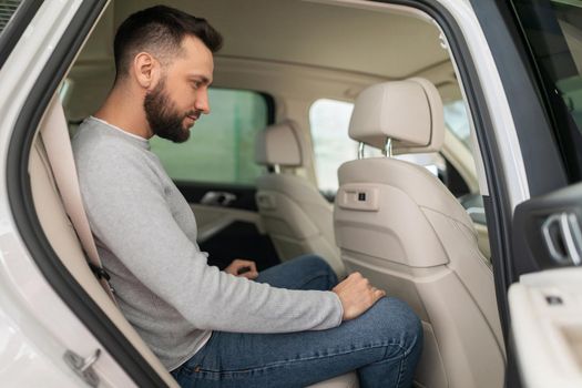 the buyer is determined with the choice of a new car sitting in the back seat of an SUV in a car dealership.