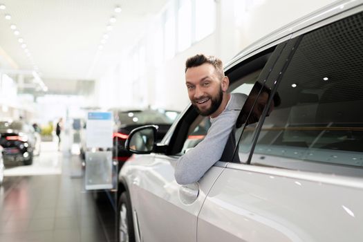 sales manager in a car dealership hands over the keys and documents to the car.