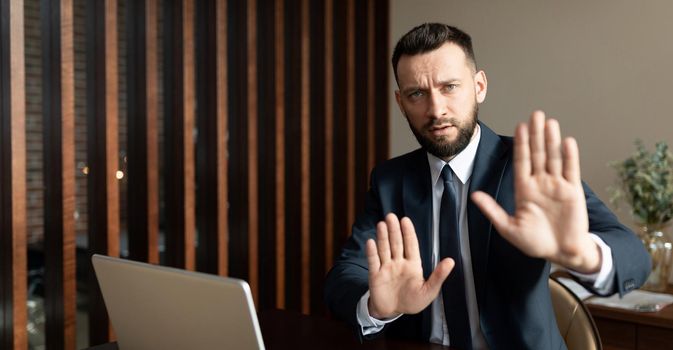 businessman refuses to work with partner due to cancellation policy, man in business suit in modern office gesturing no.
