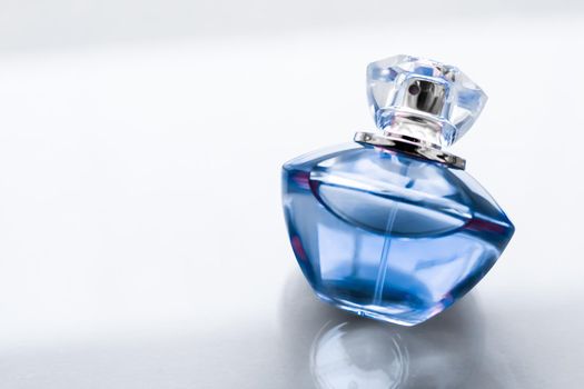 Perfumery, spa and branding concept - Blue perfume bottle on glossy background, sweet floral scent, glamour fragrance and eau de parfum as holiday gift and luxury beauty cosmetics brand design