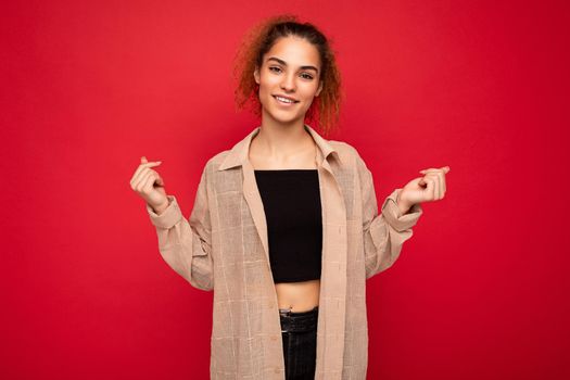 Photo of beautiful positive smiling adult woman wearing stylish clothes standing isolated on colorful background with copy space looking at camera.