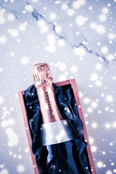 Celebration, drinks and branding concept - Champagne bottle and gift box on blue holiday glitter, New Years, Christmas, Valentines Day, winter present and luxury product packaging for beverage brand