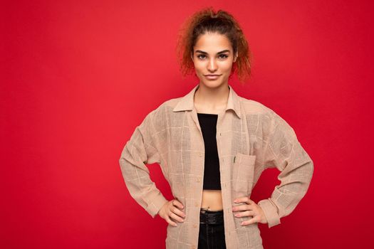 Photo of beautiful positive smiling adult woman wearing stylish clothes standing isolated on colorful background with copy space looking at camera.