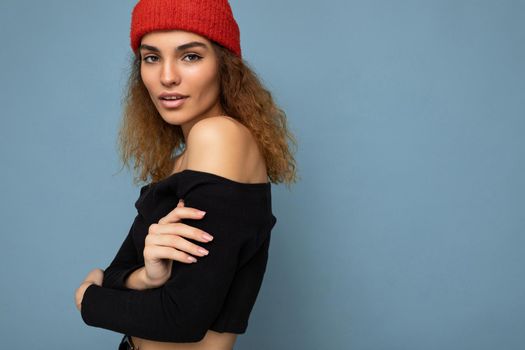 Side-profile photo of pretty sexy happy young dark blonde woman standing isolated over colourful background wall wearing everyday trendy clothes looking at camera. Empty space, copy space