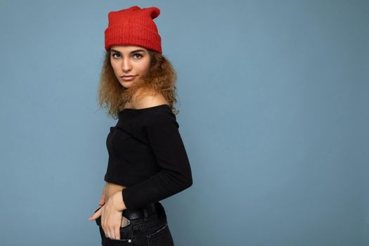 Beautiful young brunette woman isolated over blue background wall wearing casual stylish clothes feeling sincere emotions lookingat camera. copy space