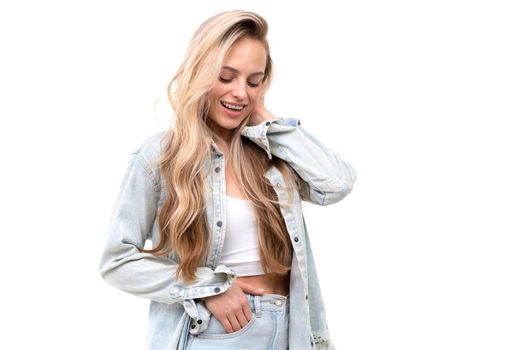 flirty beautiful blonde on a white background in a light denim suit.