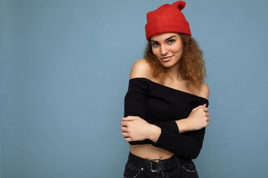 Attractive smiling happy young dark blonde woman standing isolated over colorful background wall wearing everyday stylish outfit showing facial emotions looking at camera. Empty space, copy space
