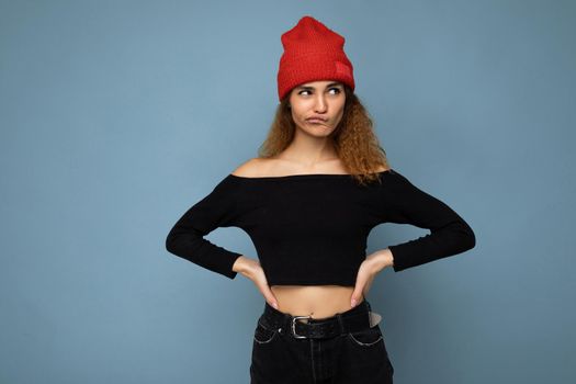 Beautiful young brunette woman isolated over blue background wall wearing casual stylish clothes feeling sincere emotions looking to the side. copy space